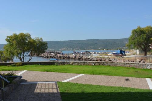 a park with a field of grass and a body of water at Palaiologou Panorama Apartments in Mantamádos