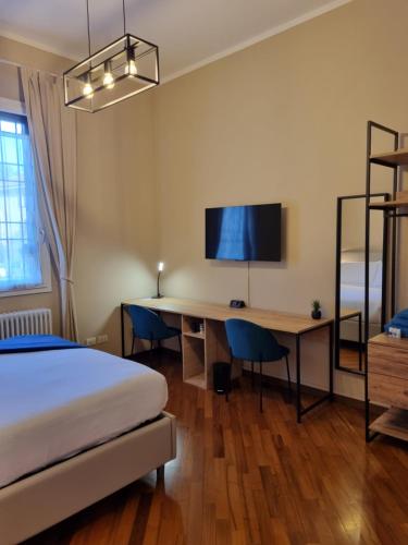 a bedroom with a bed and a desk with a television at Alemanni54 - Apartment in Bologna