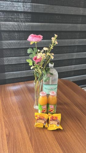 a table with a vase of flowers and a jar of food at Departamento un ambiente centro Puchuncaví in Puchuncaví