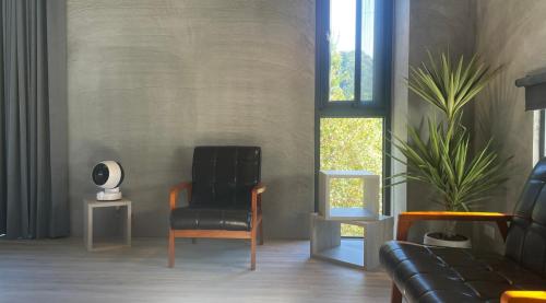 a living room with a black chair and a plant at 2025 全新開幕 四蒔旅宿 Sizhu Resort in Yuchi