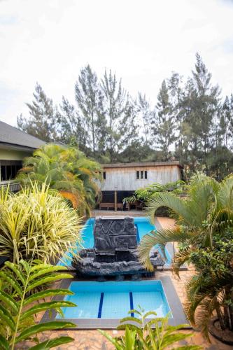 ジンジャにあるMirembe Hotels - Source of the Nile Suitesの庭に滝のあるスイミングプール