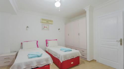 a bedroom with two beds and white cabinets at Villa Panorama, Kalkan, Private Pool, Panoramic Sea View in Kalkan