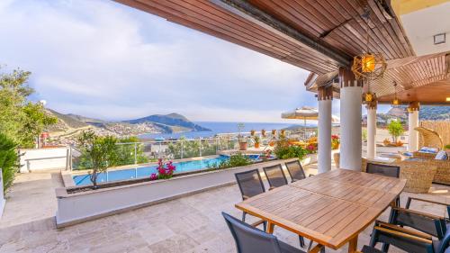 a patio with a table and chairs and a view of the ocean at Villa Panorama, Kalkan, Private Pool, Panoramic Sea View in Kalkan