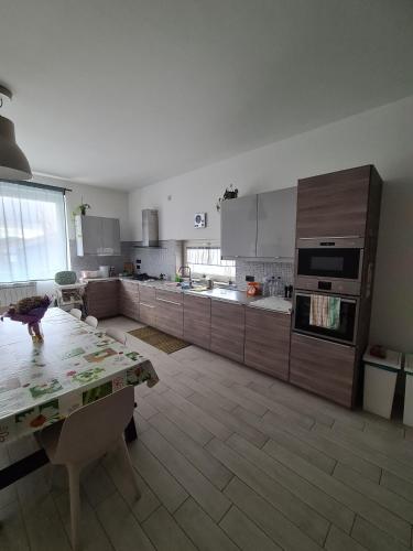 a large kitchen with wooden cabinets and a table at Casa Vacanze Mercolino in Bracigliano