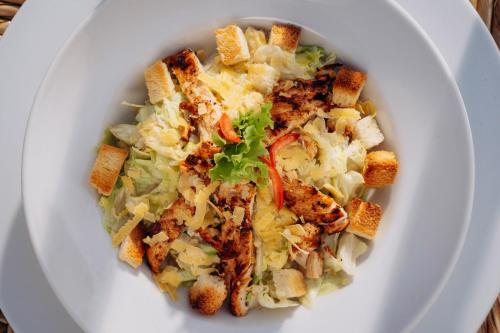 a white plate of food with a bowl of coleslaw at Seti Abu Simbel Lake Resort in Abu Simbel