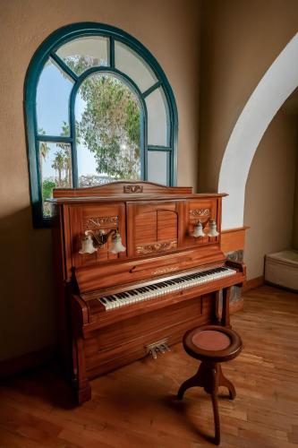 a piano with a stool in a room with a window at Seti Abu Simbel Lake Resort in Abu Simbel