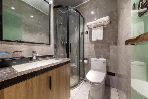 a bathroom with a toilet and a sink and a shower at 厦门中山海滨酒店 in Xiamen