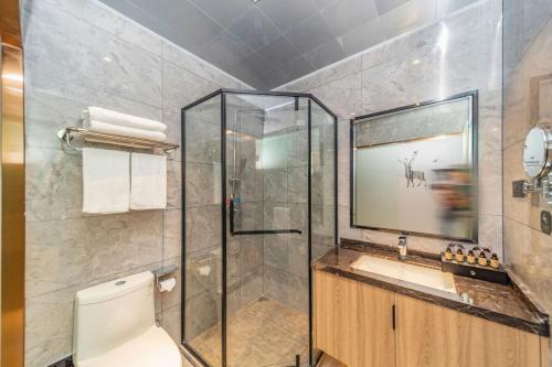 a bathroom with a shower and a toilet and a sink at 厦门中山海滨酒店 in Xiamen