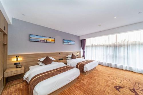 a hotel room with two beds and a large window at 厦门中山海滨酒店 in Xiamen