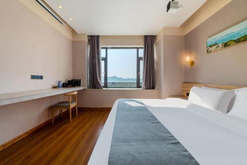 a hotel room with a large bed and a desk at 厦门中山海滨酒店 in Xiamen