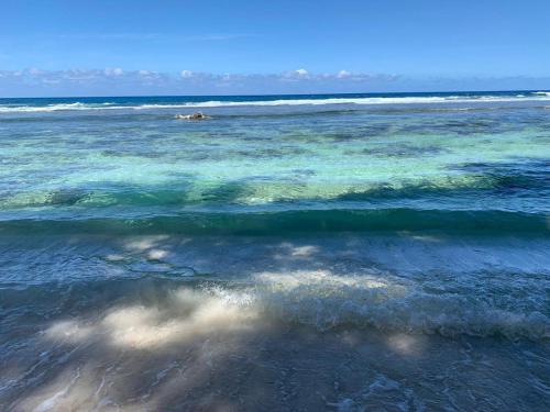 a body of water with waves and a beach at Miom Hamlet - Camping and Recreational Site, in Kavieng in Kawieng