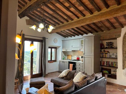 a living room with a couch and a kitchen at Casa Bella Vista in Pereta