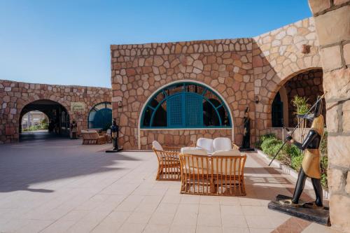 a stone building with a table and chairs on a patio at Seti Abu Simbel Lake Resort in Abu Simbel