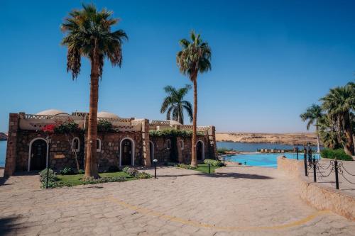 a resort with palm trees and a swimming pool at Seti Abu Simbel Lake Resort in Abu Simbel