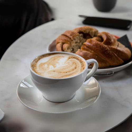 une tasse de café et une assiette de pâtisseries sur une table dans l'établissement Le Caprice des Halles, à Villaines-la-Juhel