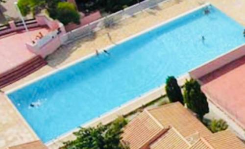 - une vue sur la grande piscine bleue dans l'établissement L Aphrodite Studio Village Naturiste, à Port-Leucate