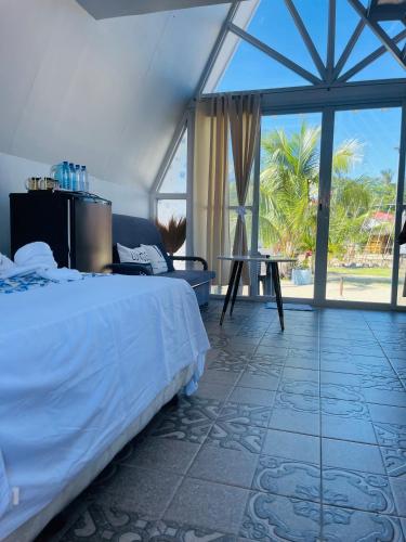 a bedroom with a bed and a large window at Bolo Hills Beach Club And Residence in Alaminos
