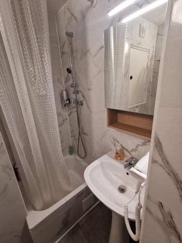 a bathroom with a sink and a shower and a toilet at Appart Hotel La Defense in Courbevoie