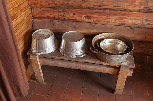 two metal buckets sitting on a wooden table at Kivi Talu Country Hotel in Otepää