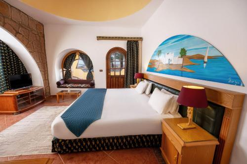 a bedroom with a bed and a large painting on the wall at Seti Abu Simbel Lake Resort in Abu Simbel