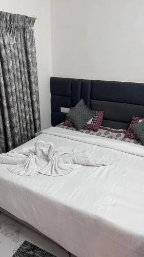 a bed with white sheets and a black headboard at Mithila - A Lovely & Peaceful 3 BHK Villa in Orchha