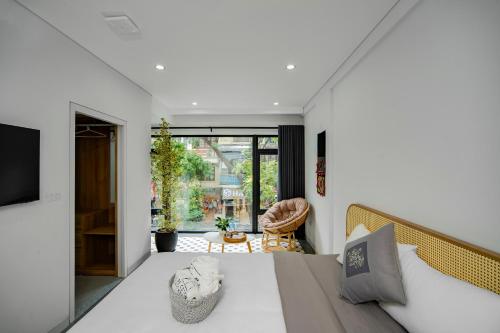 a bedroom with a large white bed and a balcony at Rue De Coton in Hanoi