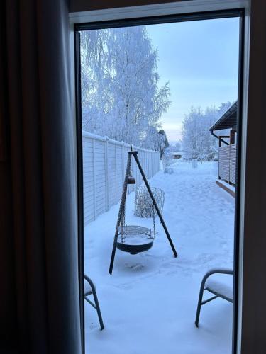 a swing in the snow outside a window at Guest house - Northern tealight in Rovaniemi