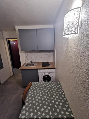 a small kitchen with a sink and a washing machine at Appart Hotel La Defense in Courbevoie