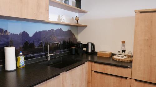 a kitchen with a sink and a counter top at Apartment Alpenland in Scheffau am Wilden Kaiser