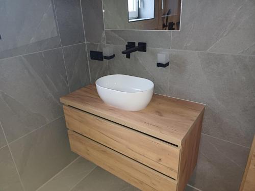 a bathroom with a bowl sink on a wooden counter at Apartment Alpenland in Scheffau am Wilden Kaiser