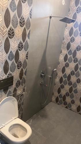 a bathroom with a toilet and a shower stall at Mithila - A Lovely & Peaceful 3 BHK Villa in Orchha
