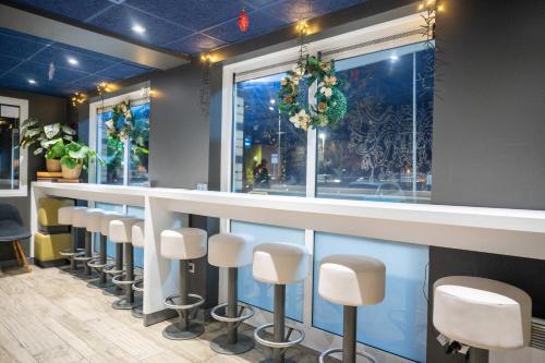 a bar with white stools in a barbershop at ibis budget London Barking in Barking