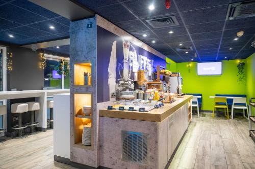 a kitchen with a counter in a room with green at ibis budget London Barking in Barking