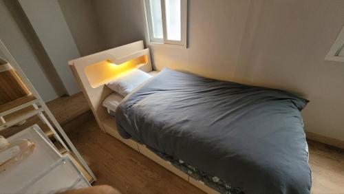 a small bedroom with a bed with a light on it at Huesik Guesthouse in Seoul