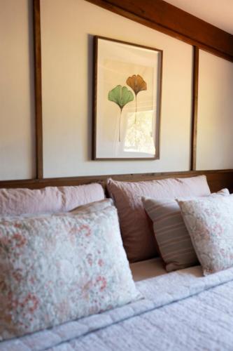 a bed with a picture on the wall above it at Cottage 2 - The Row in Forest Grove