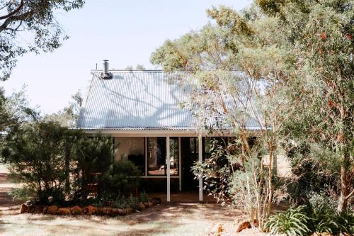 a house with a metal roof and some trees at Cottage 2 - The Row in Forest Grove