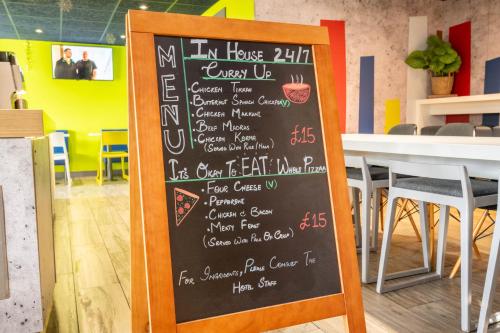 a chalkboard sign with a menu in a restaurant at ibis budget London Barking in Barking