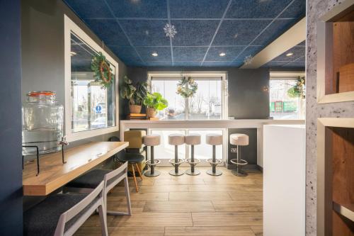 a kitchen with blue ceilings and a table and stools at ibis budget London Barking in Barking