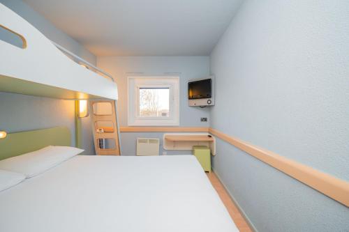 a small room with a bed and a window at ibis budget London Barking in Barking