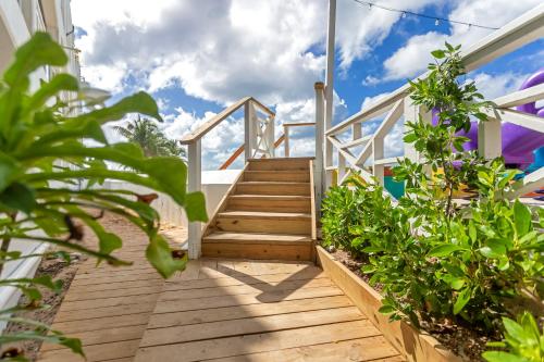 a wooden staircase leading up to a house with plants at Maho Beach House - Premier 1-Bedroom, Oceanview Suite in Maho Reef