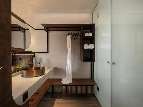 a kitchen with a sink and a dress hanging on a shelf at Geraniotis Hotel and Resort in Plataniás