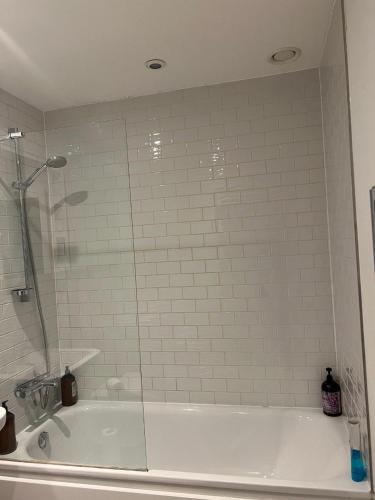 a bathroom with a tub with a glass shower at Modern Hi-rse 1bedroom Apartment in Woolwich