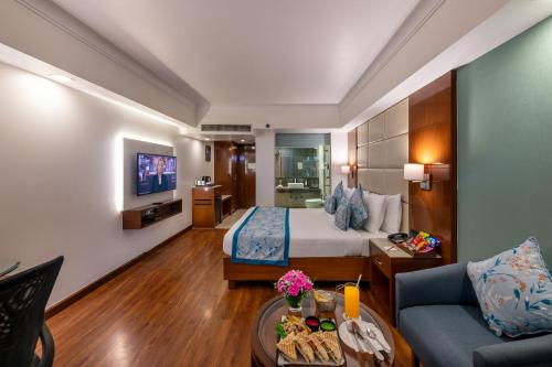 a hotel room with a bed and a couch at Lords Plaza Jaipur in Jaipur