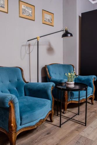 a living room with two blue chairs and a table at Old Town by Humpback in Craiova