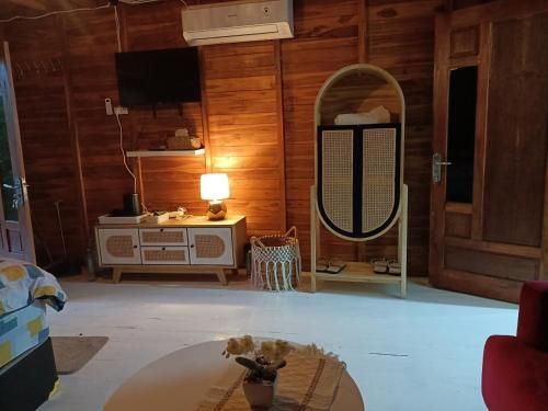 a living room with a mirror and a table at Villa Hening Senja Borobudur in Kayuares
