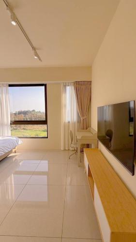 a bedroom with a bed and a large screen television at 鹿港 尋鹿好旅 民宿 in Lugang