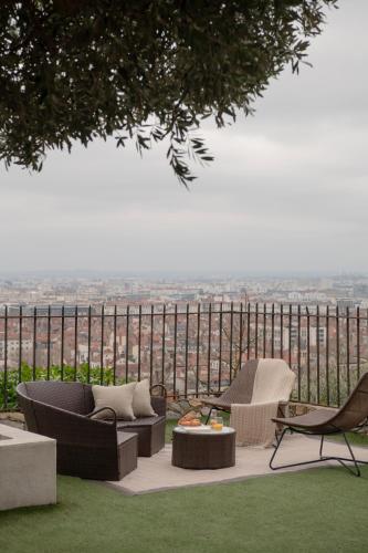 a patio with two chairs and a couch and a table at MiHotel Le Gourguillon in Lyon