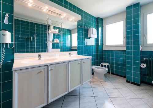a bathroom with a sink and a toilet at Grand Hôtel des Rasses & Wellness in Les Rasses