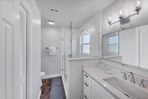 a white bathroom with a sink and a shower at Relaxing Charlotte County Villa 5881 with Private Pool Access in Punta Gorda