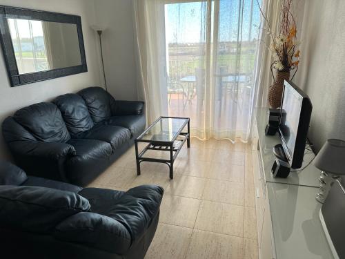 a living room with a black leather couch and a glass table at Appartement Dolores in Dolores